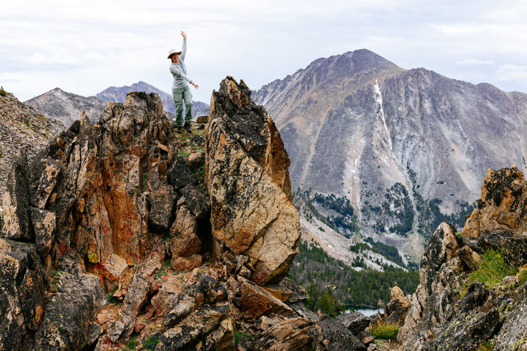 Standing on a rocky overlook with mountain views above an alpine lake in Montana.
